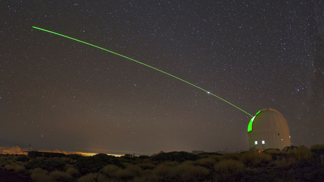 Ein sichtbarer grüner Laser strahlt von der optischen Bodenstation (OGS) der ESA